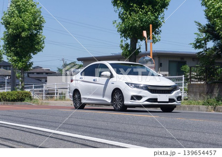 道路を走る白いハイブリッドセダン 道路を走る白いハイブリッドセダン 139654457