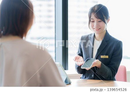 スマートフォンの説明をする女性の販売員 スマートフォンの説明をする女性の販売員 139654526