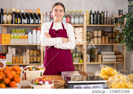 Smiling saleswoman behind the store counter Smiling saleswoman behind the store counter 139655266
