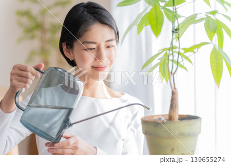 観葉植物にジョウロで水やりする女性 観葉植物にジョウロで水やりする女性 139655274
