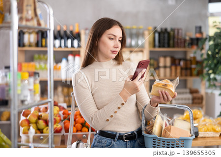 Young woman scanning qr code of cheese 139655305