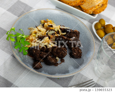 Morcilla con cebolla - fried blood sausage with onion on table Morcilla con cebolla - fried blood sausage with onion on table 139655323