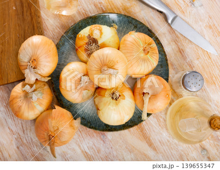Yellow onion on kitchen table, food preparation Yellow onion on kitchen table, food preparation 139655347