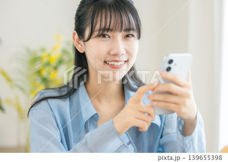 朝支度をする若い女性 スマホ 朝支度をする若い女性 スマホ 139655398