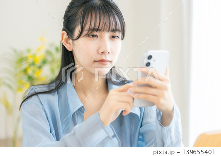 スマホを見て考える女性 スマホを見て考える女性 139655401