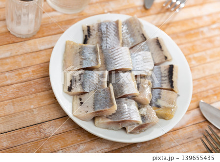 Pieces of pickled herring on a plate 139655435