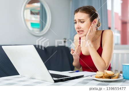 Woman with toothache having online consultation at home 139655477