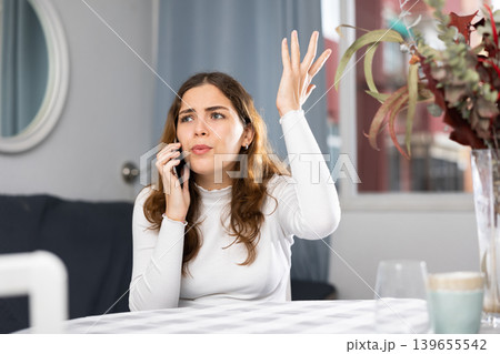 Stressed young woman using phone at home 139655542