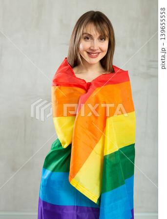Portrait of playful girl holding an LGBT flag in her hands Portrait of playful girl holding an LGBT flag in her hands 139655558