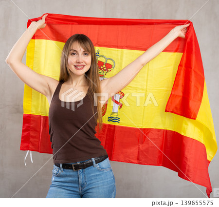 Young happy pretty woman displaying flag of spain Young happy pretty woman displaying flag of spain 139655575