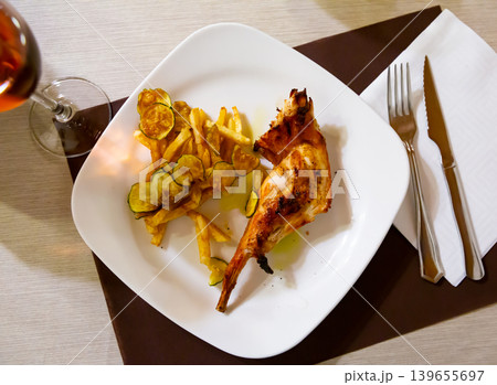Dish of fried rabbit and French fries. 139655697