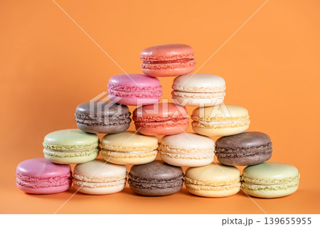 Sweet Colorful Macarons on Bright Orange Surface. 139655955