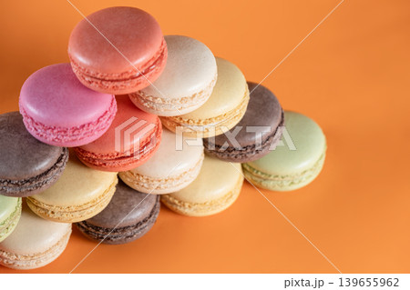 Sweet Colorful Macarons on Bright Orange Surface. Sweet Colorful Macarons on Bright Orange Surface. 139655962