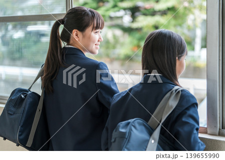 学校の廊下で会話する制服姿の中学生の女子生徒 学校の廊下で会話する制服姿の中学生の女子生徒 139655990