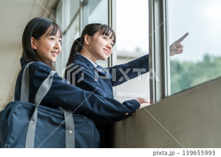学校の廊下で会話する制服姿の中学生の女子生徒 学校の廊下で会話する制服姿の中学生の女子生徒 139655993