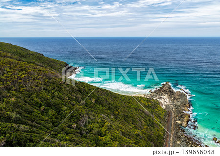 Aerial view of Sharkies Beach with tree covered mountain and rocky coastline Aerial view of Sharkies Beach with tree covered mountain and rocky coastline 139656038