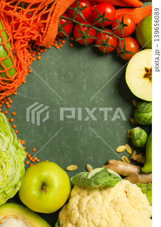 A variety of vegetables and fruits placed on a green surface 139656089
