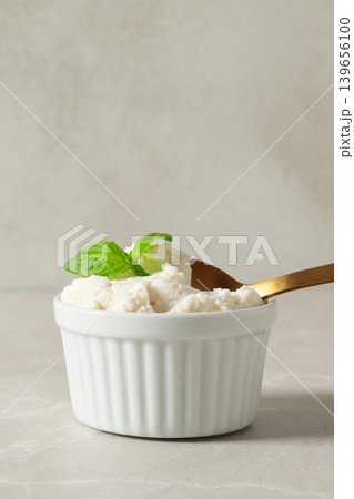 Bowl of white cheese with a spoon and mint leaves on top Bowl of white cheese with a spoon and mint leaves on top 139656100