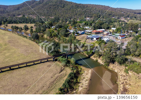 Aerial view of a railway bridge spanning the Hunter River with the township of Paterson visible in the background in New South Wales Australia. Drone photograph captures the historic rail bridge, Aerial view of a railway bridge spanning the Hunter River with the township of Paterson visible in the background in New South Wales Australia. Drone photograph captures the historic rail bridge, 139656150