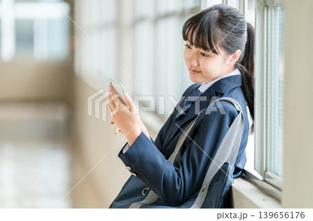 校舎の廊下でスマホを使う笑顔の小学生,中学生,高校生の女の子(防犯,安全,安心) 校舎の廊下でスマホを使う笑顔の小学生,中学生,高校生の女の子(防犯,安全,安心) 139656176