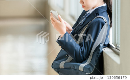 校舎の廊下でスマホを使う笑顔の小学生,中学生,高校生の女の子(防犯,安全,安心) 校舎の廊下でスマホを使う笑顔の小学生,中学生,高校生の女の子(防犯,安全,安心) 139656179