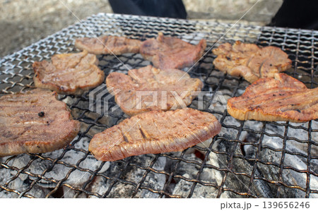 アウトドアで炭火焼きされる厚切りの牛タン 139656246