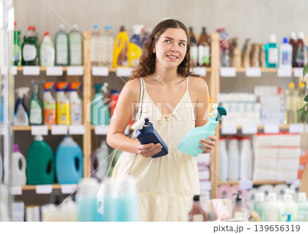 Young woman choosing cleaning spray in household store 139656319