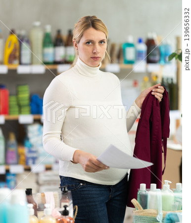 Worried pregnant store employee reading maternity leave documents 139656332