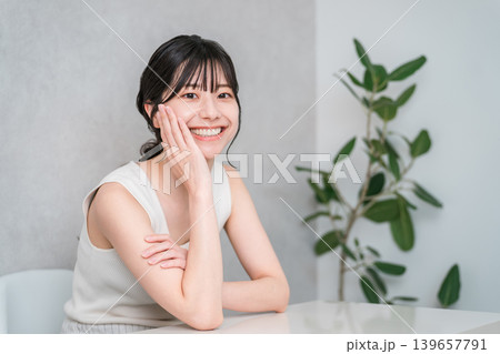 頬杖をつく美肌の笑顔のアジア人女性(美容・エステ・スキンケアイメージ) 頬杖をつく美肌の笑顔のアジア人女性(美容・エステ・スキンケアイメージ) 139657791
