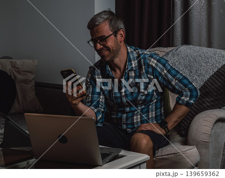 Man using smartphone during remote work at home 139659362