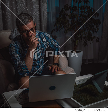 Freelancer concentrating on online work at night Freelancer concentrating on online work at night 139659367