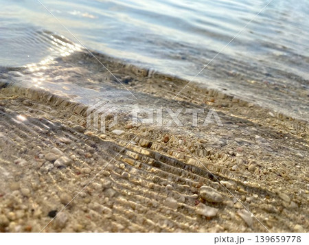 透明度が高い夏の波打ち際と砂浜の水面 透明度が高い夏の波打ち際と砂浜の水面 139659778