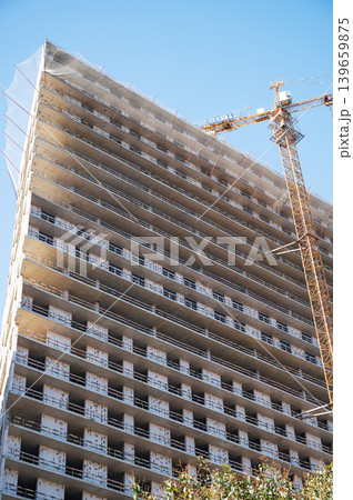 High-rise building under construction with tower crane, urban development and real estate concept 139659875