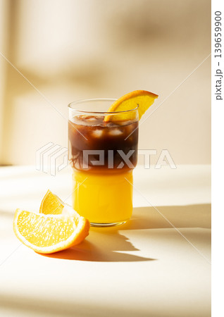 Cold bumble coffee with orange juice and ice on yellow background 139659900