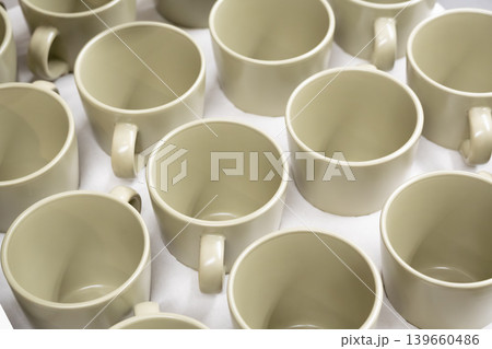 White cups and mugs in crockery shop, ceramic dishware, tableware stack in store White cups and mugs in crockery shop, ceramic dishware, tableware stack in store 139660486