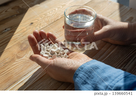 Pills in a woman hand, taking painkillers, medical tablets Pills in a woman hand, taking painkillers, medical tablets 139660541