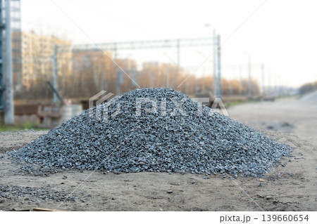 Construction gravel pile, crushed grey stone on ground Construction gravel pile, crushed grey stone on ground 139660654