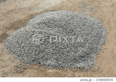 Construction gravel pile, crushed grey stone on ground Construction gravel pile, crushed grey stone on ground 139660656