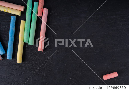 Colorful chalks pile on black background, different colors crayons on dark stone plate 139660720