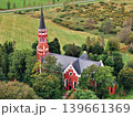 Halliste, Estonia September 25, 2025: Stensele Church showing its red brick architecture and tall spire, surrounded by green trees in a rural Swedish landscape 139661369