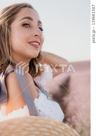 Woman lavender portrait smiling young lady looks away in a purple field at golden hour enjoying summer peacefulness and copy space 139661387