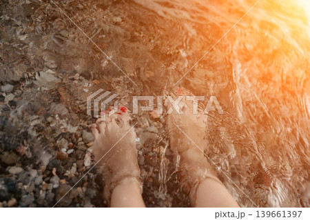 Feet water pebbles in clear ocean during relaxing summer beach vacation Feet water pebbles in clear ocean during relaxing summer beach vacation 139661397