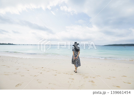 与那覇前浜ビーチから来間大橋をながめる麦わら帽子をかぶった女性 与那覇前浜ビーチから来間大橋をながめる麦わら帽子をかぶった女性 139661454