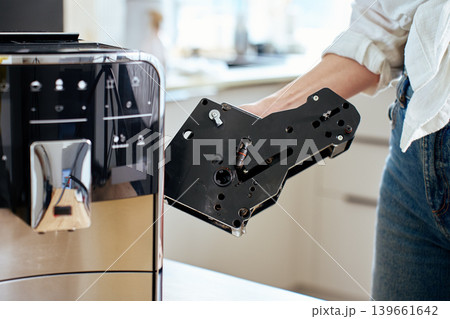 Woman removing internal unit from coffee machine 139661642