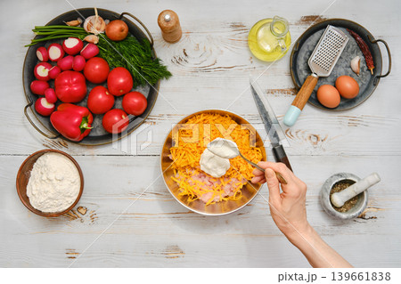 Preparing a dish with fresh ingredients and tools on a wooden table in a home kitchen 139661838