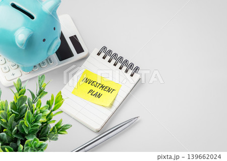 Investmentt plan note with blue piggy bank on calculator on desk, financial strategy, wealth management, and future investment planning 139662024