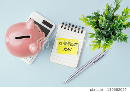 Top view of piggy bank with retirement plan note and calculator on desk, concept for senior financial planning, pension funds, and future wealth management. 139662025