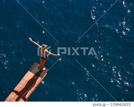 a female professional swimmer about to dive into the sea a female professional swimmer about to dive into the sea 139662635