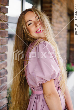 Smiling Blonde Woman In Pink Dress Outdoors Smiling Blonde Woman In Pink Dress Outdoors 139663536
