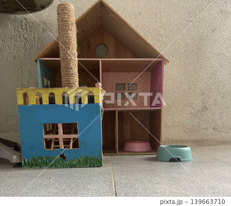 Colorful playhouse and scratching post in a room with tiled floor and wall background at midday 139663710